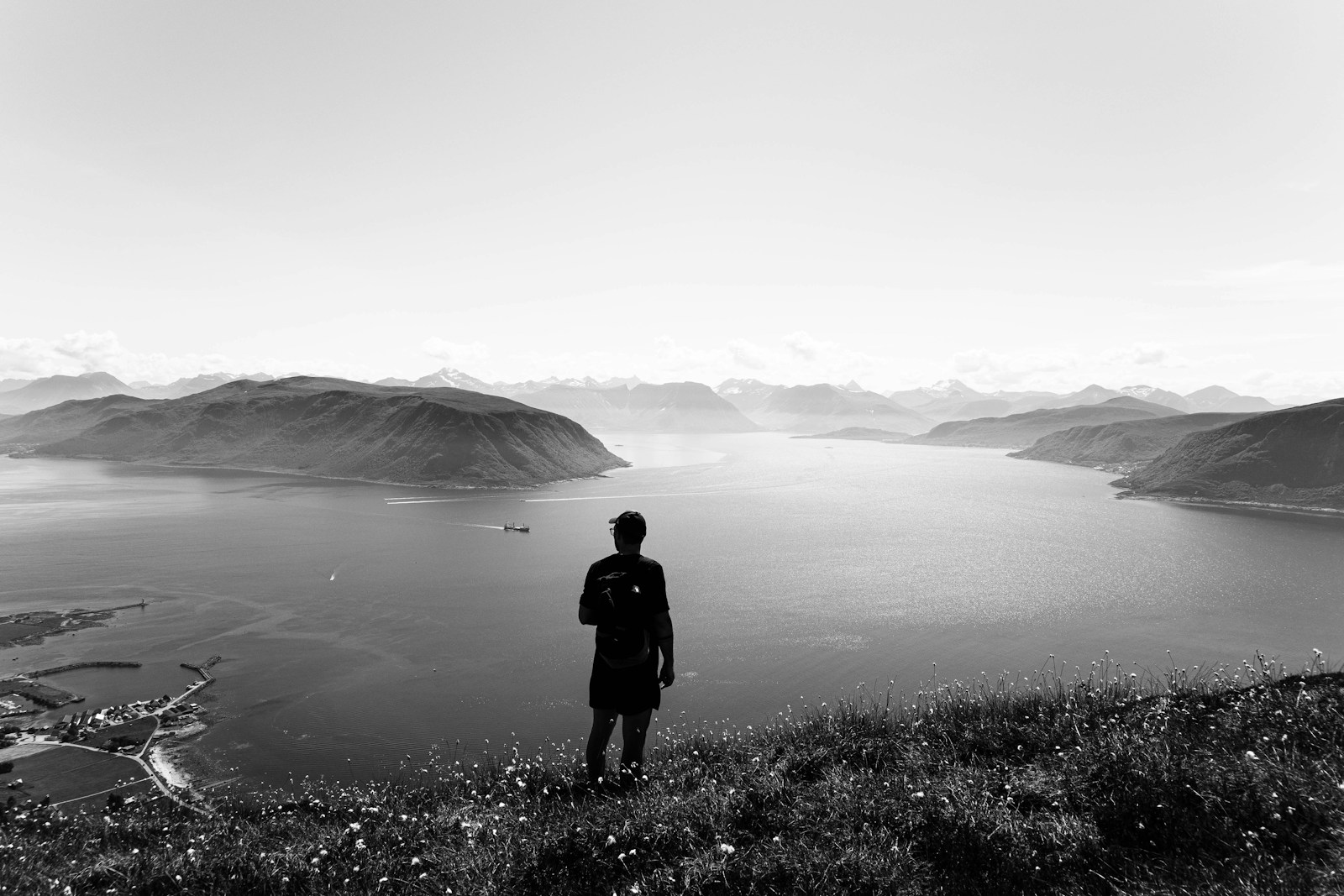 a man standing on top of a hill next to a lake